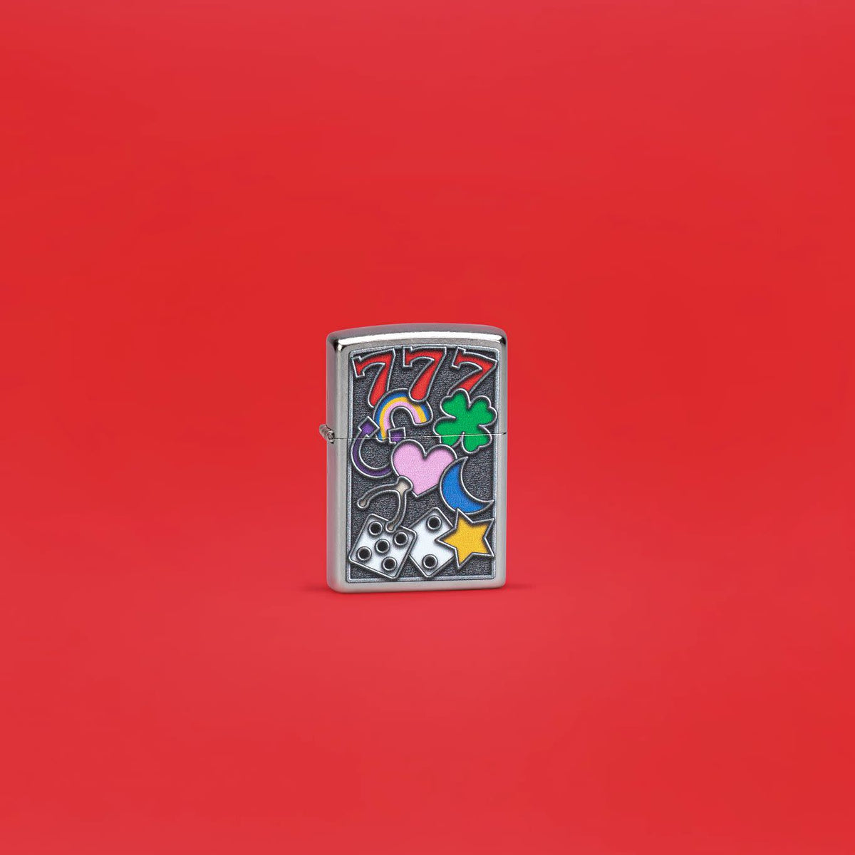 Lifestyle image of Zippo All Luck Design Street Chrome Windproof Lighter standing in a red scene.